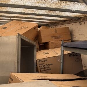 IMG_6643 - Montana Auctions by Kevin Hill Stacked cardboard boxes labeled Genpak Snap-It Large Hinged Sandwich Containers fill the back of a truck.