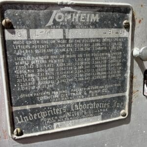 IMG_6808 - Montana Auctions by Kevin Hill Weathered metal identification plate on industrial equipment listing model, serial number, and patents for Tokheim gas-pump gear.