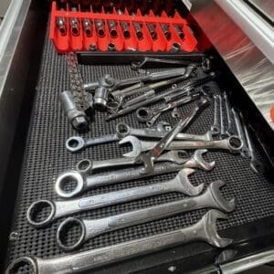 Drawer of metal hand tools with assorted wrenches and sockets; a red plastic socket organizer sits in the back of the tray.