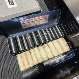 Open blue tool tray with a 12-piece deep air impact socket set and a beige rolled abrasive pad; label reads '12 PC Deep Air Impact Socket Set'