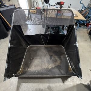 Open, fabric-covered rectangular enclosure with a metal frame in a workshop; likely a DIY dust-collection or containment booth for sanding/grinding tasks.