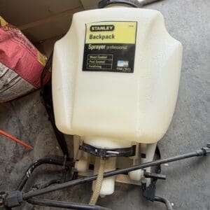 Stanley backpack sprayer on a concrete floor, labeled 'Backpack Sprayer professional' for weed, pest, and fertilizer control (4 gal).