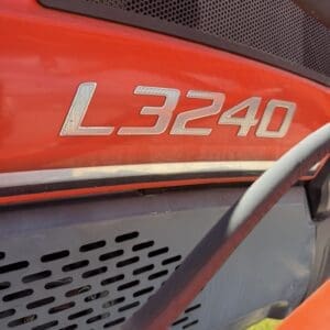Red tractor hood featuring a silver 'L3240' model badge with a black vent/grill in the background.