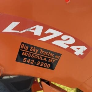 Orange tractor hood with large white 'LA724' lettering and a black label reading 'Big Sky Tractor, Inc., Missoula, MT 542-2200'