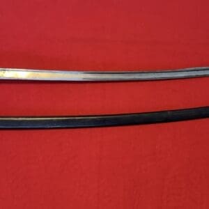 A long sword with a brass guard and leather-wrapped grip lies above a black scabbard on a red fabric background.