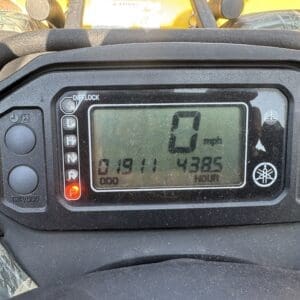 Digital instrument cluster on a yellow vehicle showing 0 mph, with odometer and hour meter readings and the gear in Park (P).