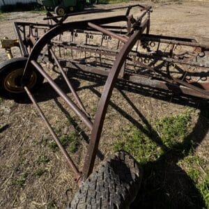 LOT 2 2 - Montana Auctions by Kevin Hill Rusty metal farming implement with wheels and multiple tines lying on a dry field; appears abandoned in a rural area.