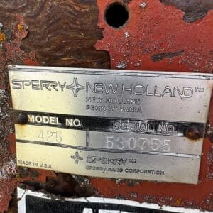LOT 4 9 - Montana Auctions by Kevin Hill Close-up of a rusted red machine with a metal nameplate reading Sperry New Holland, Model No. 425, Serial No. 530755 (Made in USA).