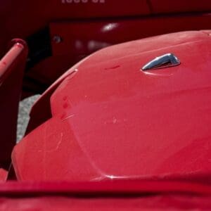 LOT 5 2 - Montana Auctions by Kevin Hill Close-up of a shiny red vintage car body with a chrome hood ornament and the numbers 1635 CL on a red panel