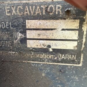 1 3 - Montana Auctions by Kevin Hill Nameplate on a dusty excavator reading EXCAVATOR with model KA121-2, serial number 20021, engine number YW0016, manufactured in Japan.