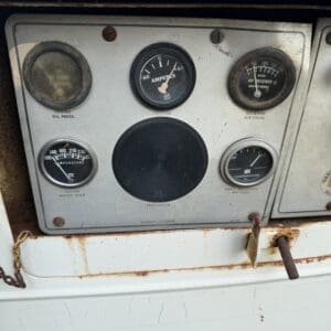 10 9 - Montana Auctions by Kevin Hill Old rusted industrial control panel with circular gauges including ammeters and temperature dials on a weathered machine surface