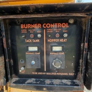 11 5 - Montana Auctions by Kevin Hill Industrial burner control panel on a yellow machine showing Tack Tank and Hopper Heat sections and temperature dials (weathered)