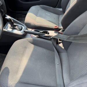 13 8 - Montana Auctions by Kevin Hill Front seats of a car interior with the center console, gear shift, and a loose seat belt across the passenger seat.