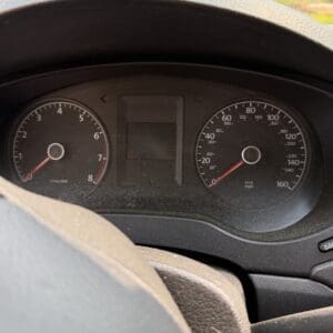 13 9 - Montana Auctions by Kevin Hill Car dashboard viewed from the driver’s seat, showing the speedometer (up to 160) and tachometer with a steering wheel in the foreground.