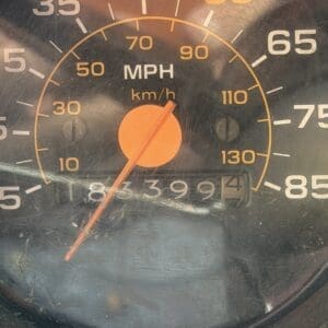18 8 - Montana Auctions by Kevin Hill Close-up of a vehicle speedometer showing mph and km/h; the orange needle sits near 0, and the odometer reads 183,994 miles.