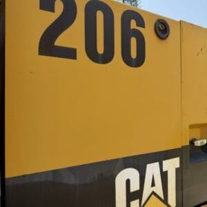 2 12 - Montana Auctions by Kevin Hill Close-up of a yellow construction machine with the number 206 and the CAT logo visible.