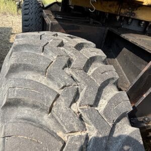 2 2 - Montana Auctions by Kevin Hill Close-up of a large off-road tire on heavy equipment with visible cracks and wear.