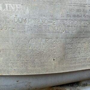 20 1 - Montana Auctions by Kevin Hill Engraved metal plate on a vehicle with tire sizes like 425/65R22.5 and date codes, dirty and weathered.