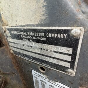 24 3 - Montana Auctions by Kevin Hill Close-up of a weathered metal nameplate on a rusted machine: 'International Harvester Company, Chicago, Illinois' with serial/model info still visible.