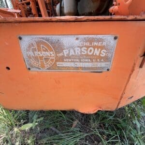 25 2 - Montana Auctions by Kevin Hill Close-up of an orange construction machine with a weathered metal plate reading PARSONS, NEWTON, IOWA, U.S.A.