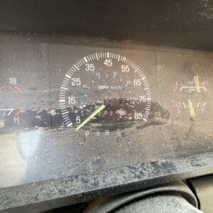 26 3 - Montana Auctions by Kevin Hill Dusty car dashboard with a central speedometer (0–85 mph) and small fuel and temperature gauges on the sides.