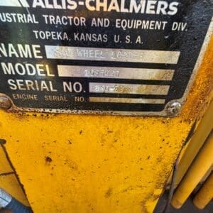 3 9 - Montana Auctions by Kevin Hill Plate on a yellow Allis-Chalmers wheel loader showing model 1095440 and serial 840-2935, with location Topeka, Kansas USA.