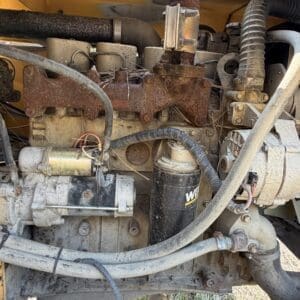 5 3 - Montana Auctions by Kevin Hill Diesel engine compartment with rusty exhaust manifold and various hoses and wires exposed