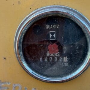 5 5 - Montana Auctions by Kevin Hill Close-up of a round quartz hour meter mounted on yellow equipment, showing 4,782 hours and a red center cover behind a chrome bezel.
