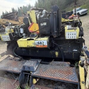 8 1 - Montana Auctions by Kevin Hill Heavy yellow and black industrial machine with control panels, hoses, and perforated steps in an outdoor yard.