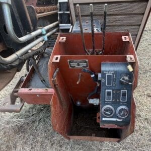 9 2 - Montana Auctions by Kevin Hill Close-up of a red, rusty control box on an agricultural machine showing a Cold Start switch, two track levers, and two gauges with wiring and labels visible.
