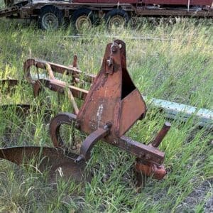 IMG_8531 - Montana Auctions by Kevin Hill Old, rusted farming implement sitting in tall grass with a trailer in the background, abandoned in a field.