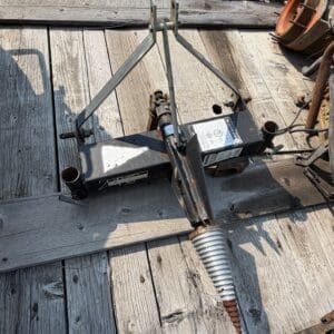 IMG_8537 - Montana Auctions by Kevin Hill Rusty auger-style anchor attached to a metal frame on a weathered wooden deck, with tools scattered nearby.