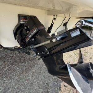 IMG_8726 - Montana Auctions by Kevin Hill Outboard motor (MerCruiser) mounted on boat stern with propeller visible and mounting bracket in dirt emergency storage area