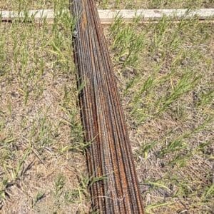 IMG_8836 - Montana Auctions by Kevin Hill Bundle of rusted steel rebar tied together lying on a grassy construction site field