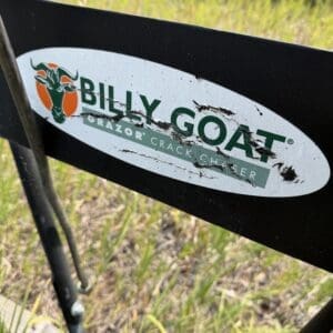 IMG_8843 - Montana Auctions by Kevin Hill Close-up of a Billy Goat sticker on outdoor equipment, showing a green goat head logo and the words BILLY GOAT on a black metal frame.