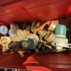 IMG_8886 - Montana Auctions by Kevin Hill Assorted gas regulators, gauges, and fittings packed in a red metal toolbox.